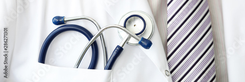 Obraz na plátně Male GP wearing tie holding stethoscope in smock pocket