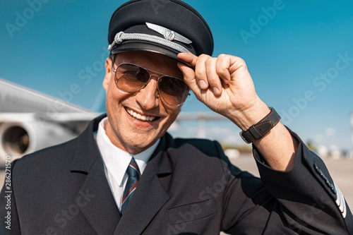 Caucasian handsome pilot in uniform greeting somebody outdoors