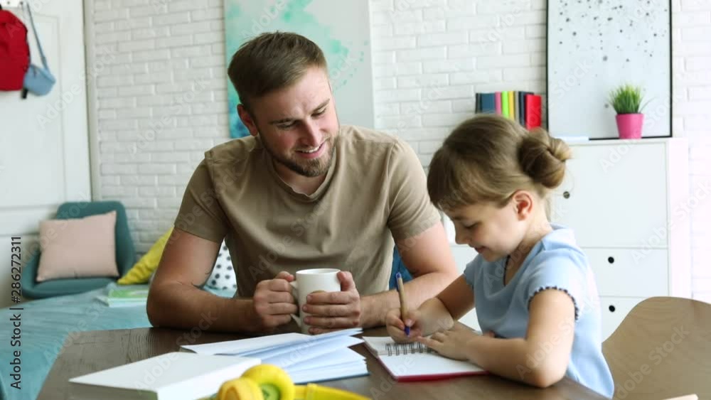 Dad helping her daughter with homework assignment in room Dad helping her daughter with homework assignment in room