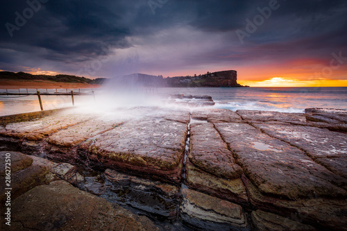Photography Sunrise sky and waves crash onto rocky beach shore