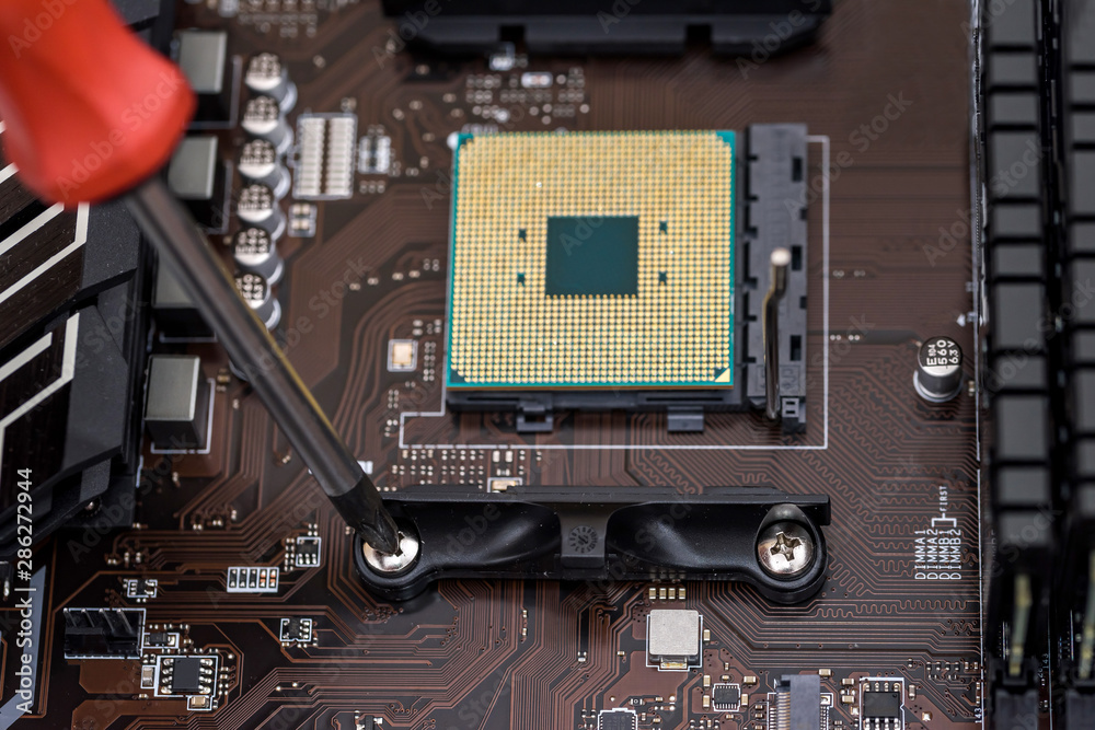 Fototapeta premium Screwdriver screw bolt on motherboard. Close up