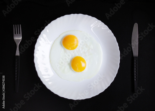 breakfast and light lunch or dinner. on a wooden table and with a black background. eggs cheese butter and coffee in white plate