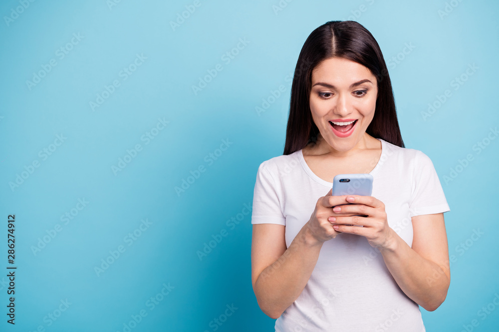Copyspace photo of nice cute cheerful girl seeing information about sales on her phone while isolated with blue background Copyspace photo of nice cute cheerful girl seeing information about sales on her phone while isolated with blue background