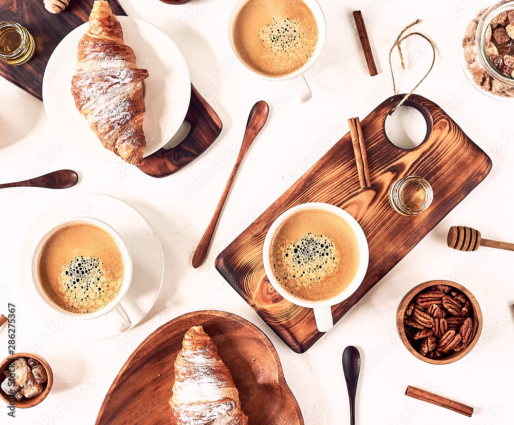 Fototapeta European breakfast, croissant cinnamon coffee, nuts, rekan, almonds, honey, spoon, wooden, top view, good morning, wake up concept, good morning. Top view.