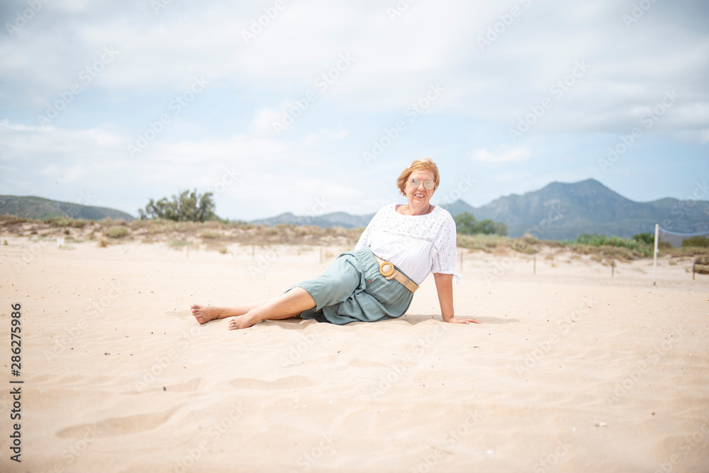 Beautiful mature woman posing on the beach