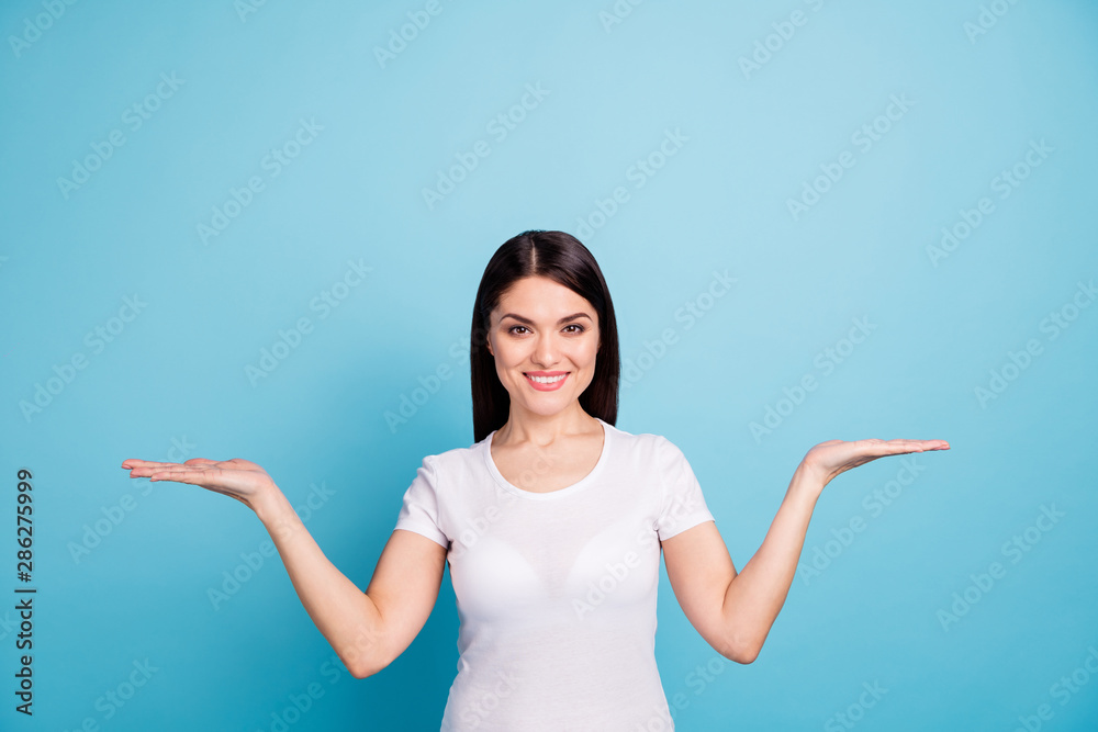 Photo of toothily smiling nice cute girl giving you chance to choose what would fit you better while isolated with blue background Photo of toothily smiling nice cute girl giving you chance to choose what would fit you better while isolated with blue background