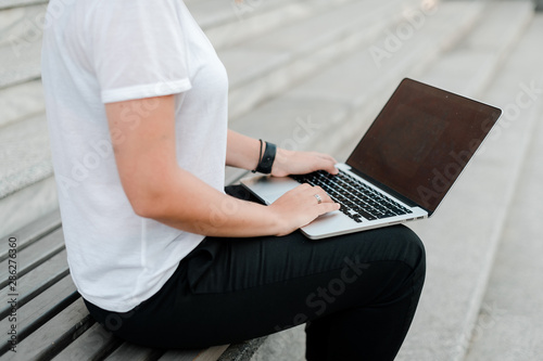 woman typing on laptop outdoors and working remotely