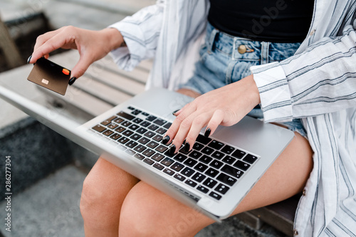 woman uses credit card and laptop