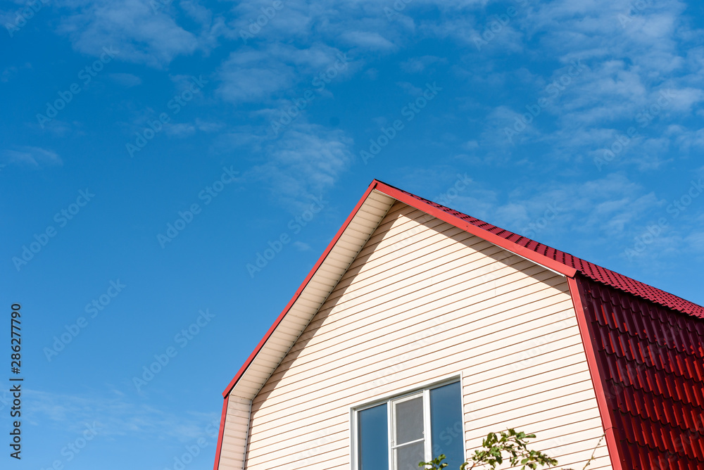 Blue sky with clouds and the roof of a country house Blue sky with clouds and the roof of a country house