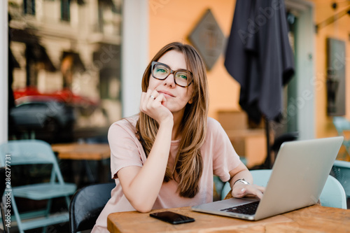 woman with laptop sitting in cafe photo