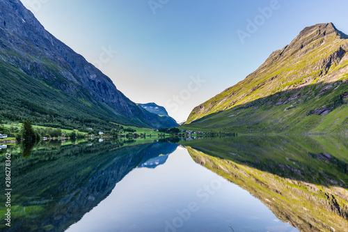 Moutains reflecting in the water of lake Eidsvatnet in Eidsdal along national scenic road 63, Trondelag county in Norway photo