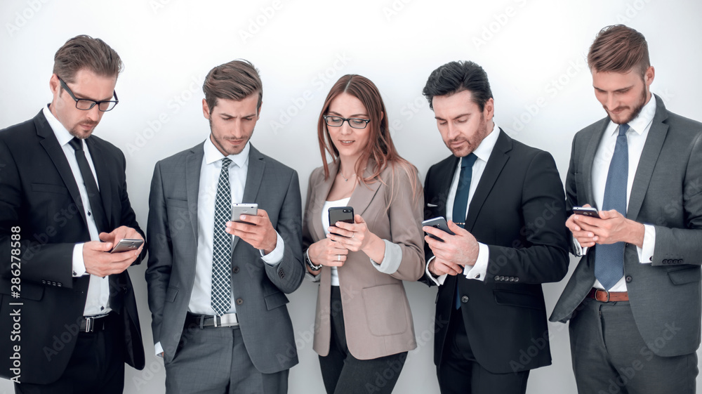 group of business people looking at the screens of their smartphones group of business people looking at the screens of their smartphones