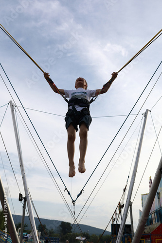 Boy jumping on bungee trampoline