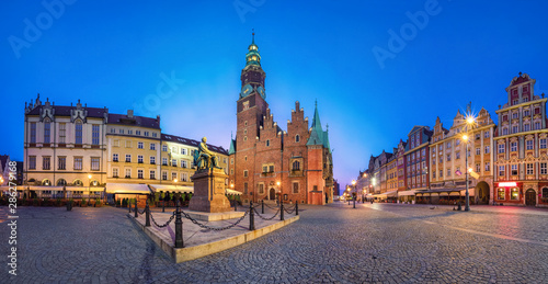Panoramic view of Rynek square in Wroclaw, Poland with gothic Town Hall and monument at dusk