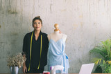 Asian female clothing designer using dress dummy, freelance lifestyle.