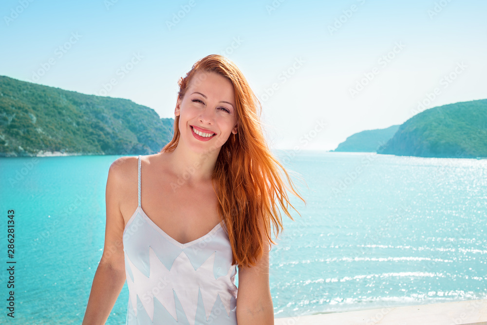 beautiful woman smiling happily and relaxing outdoor on balcony with sea beach and ocean view