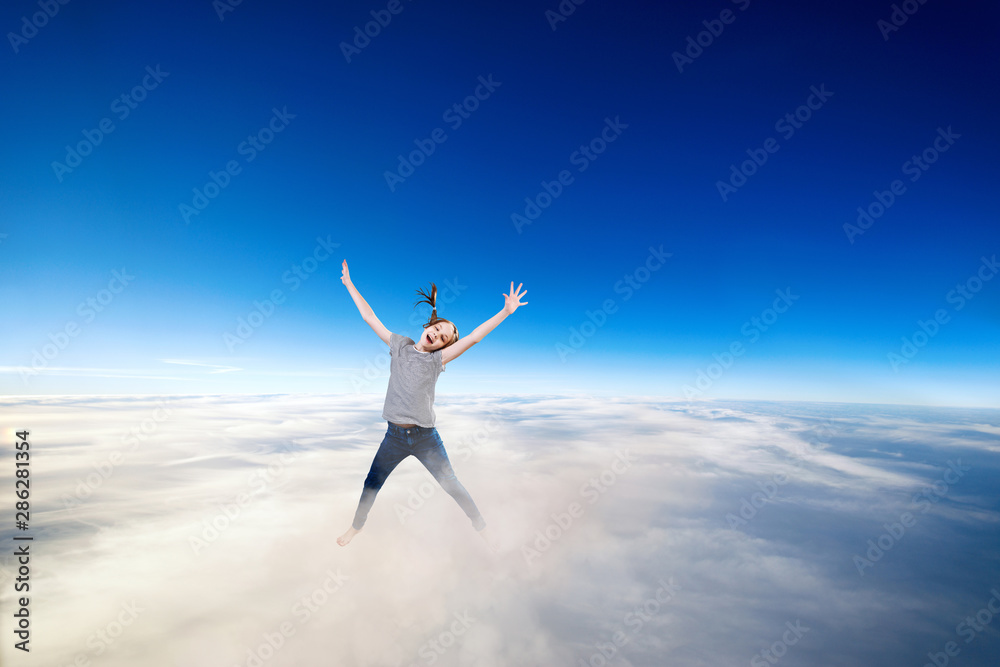 Little girl flying over clouds in the blue sky. Little girl flying over clouds in the blue sky.
