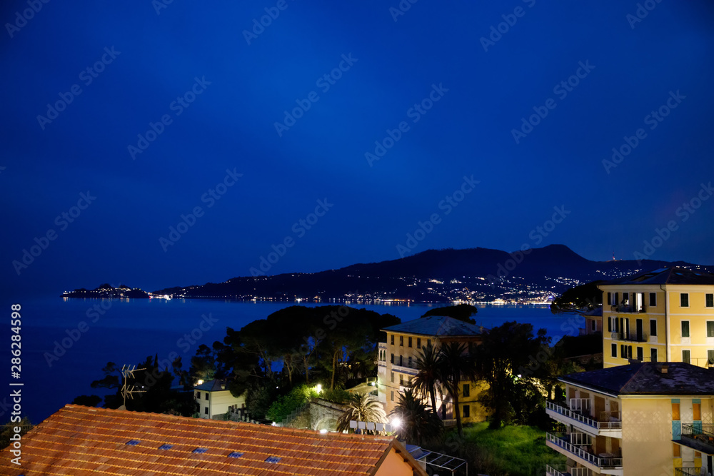 Breathtaking view from window in the night on Liguria region in Italy. Awesome villages of Zoagli, Cinque Terre and Portofino. Beautiful Italian city with colorful houses.