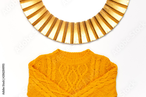 Fashionable vintage modern golden frame, knitted orange sweater isolated on white background. Photo frame, mirror frame, baguette, stylish interior item. Autumn, fall concept