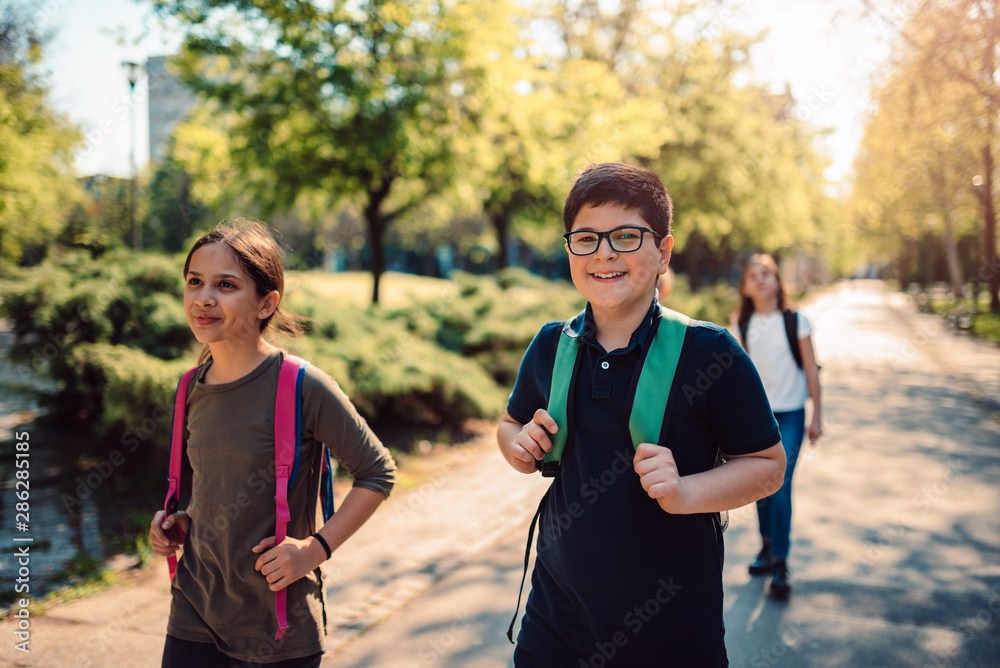 Happy school kids going together to the school