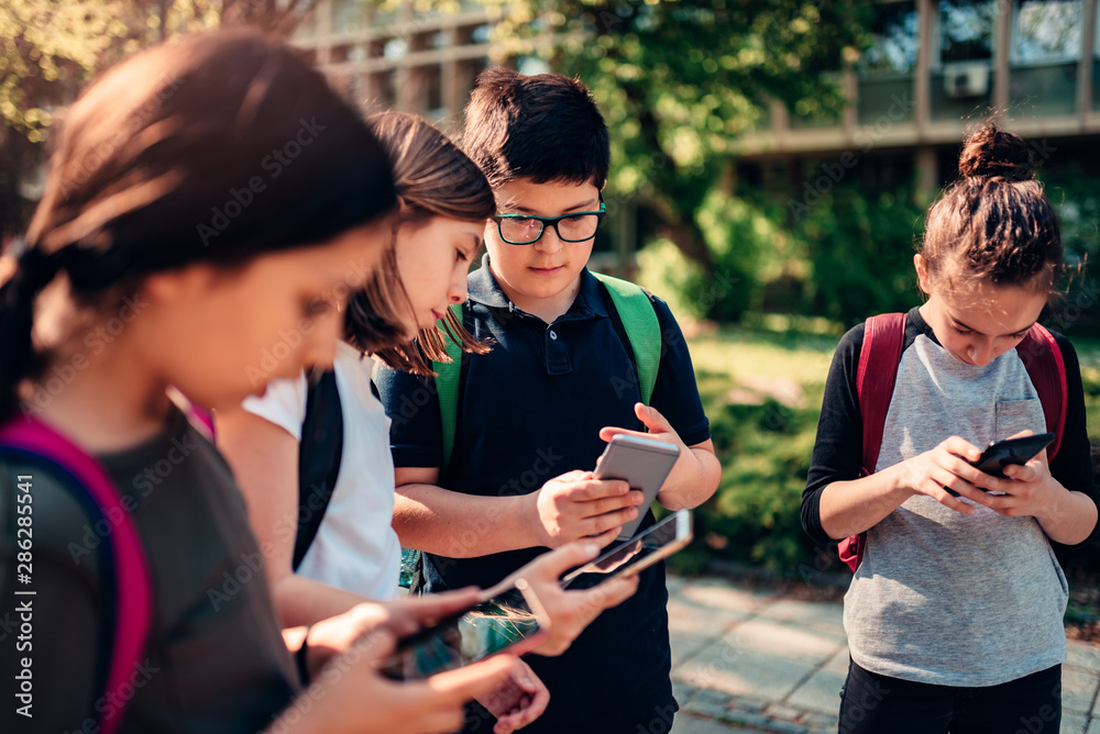 Kids playing video games on smart phone after school Kids playing video games on smart phone after school
