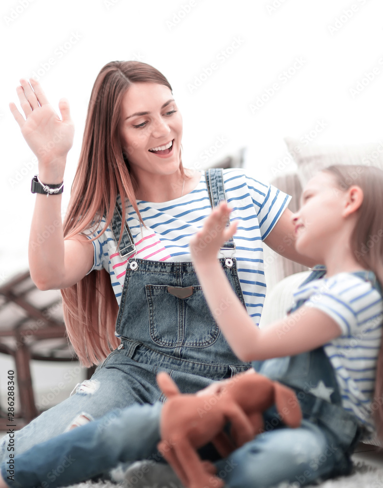 mother and her little daughter give each other a high five