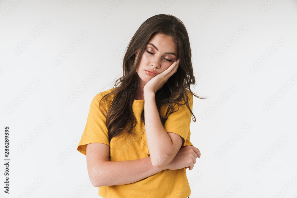 Image of tired brunette woman wearing casual clothes propping up her head with hand Image of tired brunette woman wearing casual clothes propping up her head with hand
