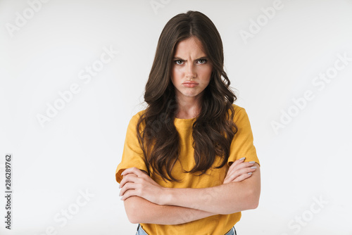 Fotografie Image of angry brunette woman wearing casual t-shirt frowning and standing with