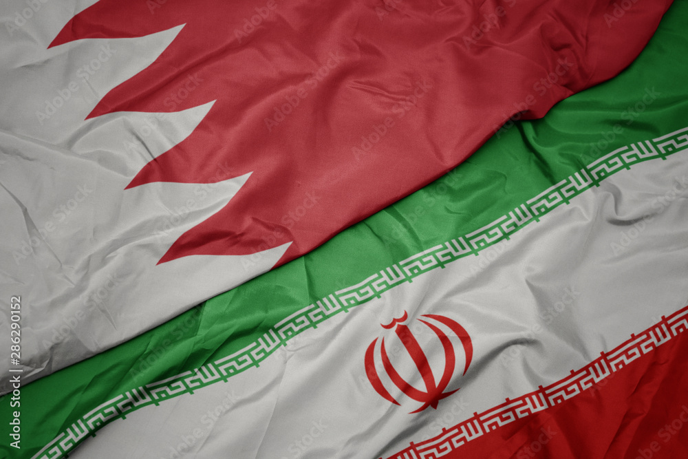 waving colorful flag of iran and national flag of bahrain.