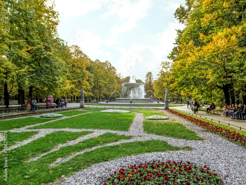 Flowerbeds with a fountain in the Saxon Garden in Warsaw (Poland) on an autumn sunny day. Beautiful scenery of the oldest public park in the center of the Polish capital