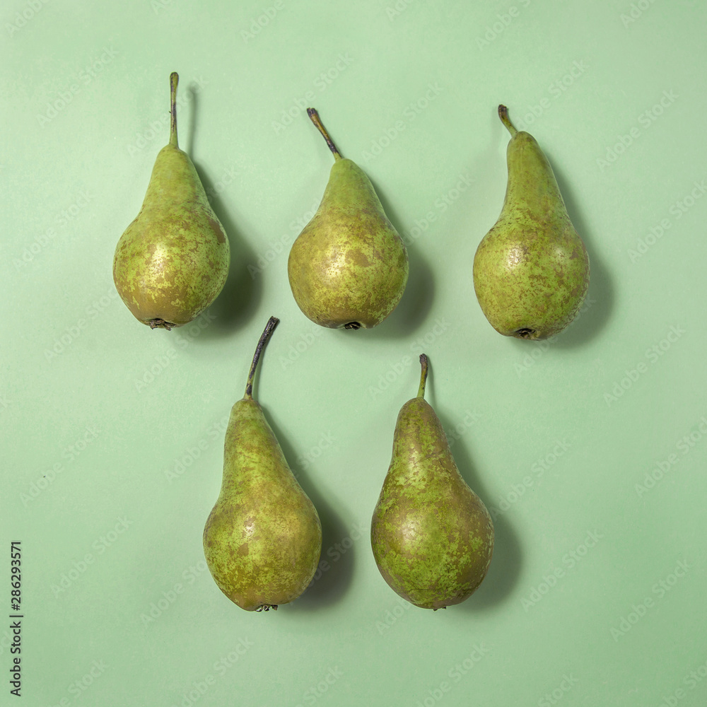 Row of fresh pears on green background. From top view, minimal food concept Row of fresh pears on green background. From top view, minimal food concept
