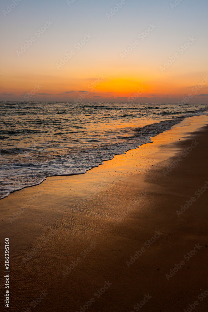 BEACH LANDSCAPE ILLUMINATED BY THE SUNSET AT THE COAST OF CADIZ IN SPAIN