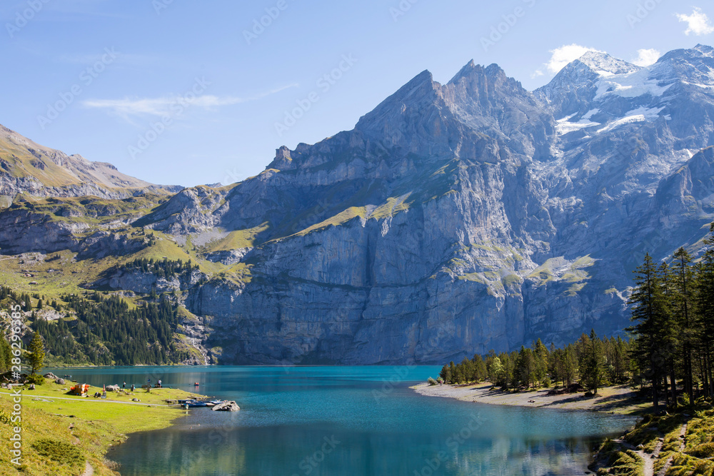 The panorama in summer view over the Oeschinensee (Oeschinen lake) and the alps on the other side near Kandersteg on bernese oberland in Switzerland.