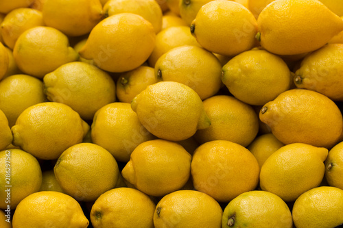 A pile of lemons at the vegetable market. Macro background of citruses.