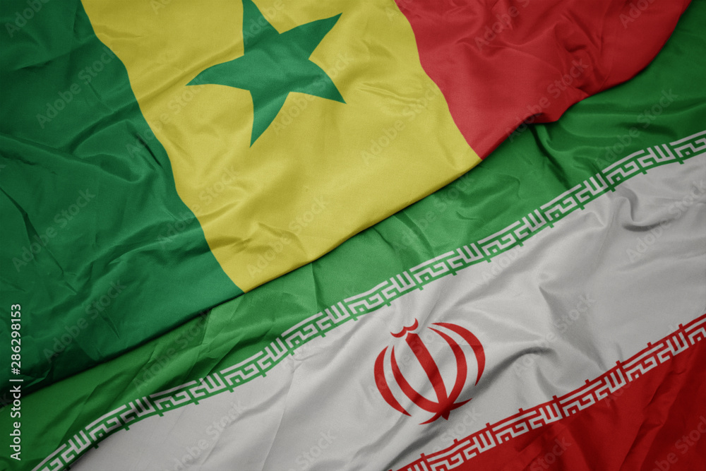 waving colorful flag of iran and national flag of senegal.