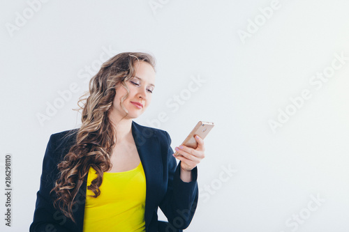 the concept of employment, interviews, digital advertising - businesswoman looking at the phone screen. Smiling woman working. Isolated on white background. Copy space. Portrait of a woman with emotio