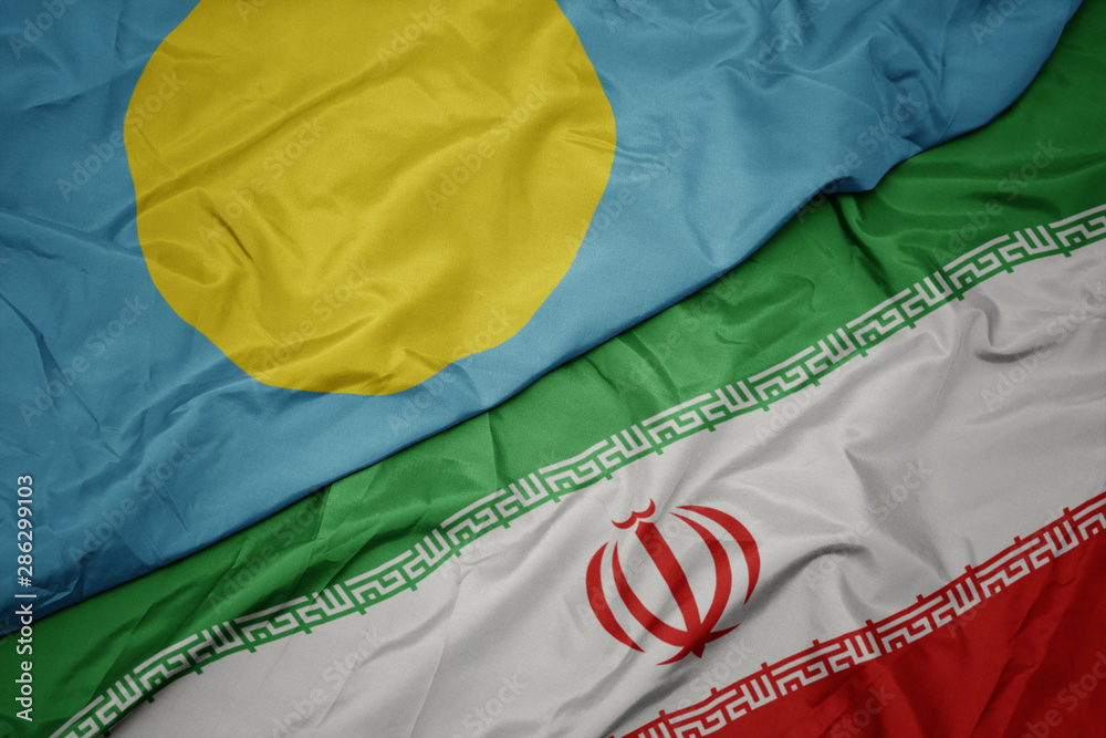 waving colorful flag of iran and national flag of Palau .