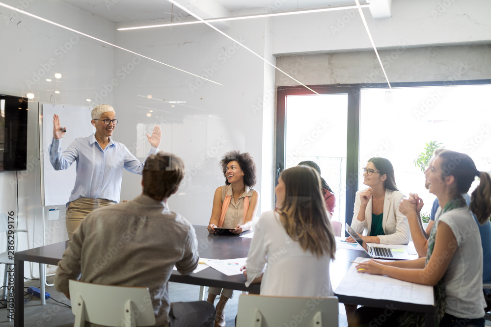 Fototapeta premium Team of colleagues brainstorming together while working in modern office
