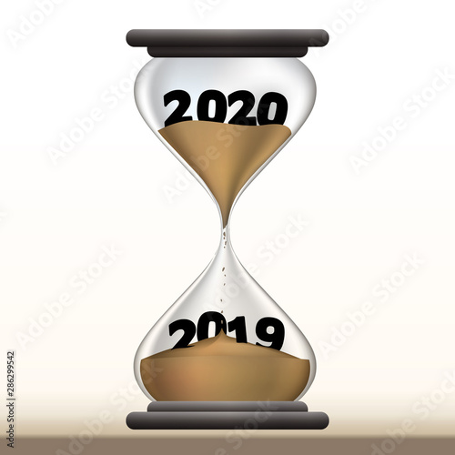 Concept du temps qui passe et du passage à la nouvelle année avec un sablier qui présente 2020 en faisant disparaître 2019