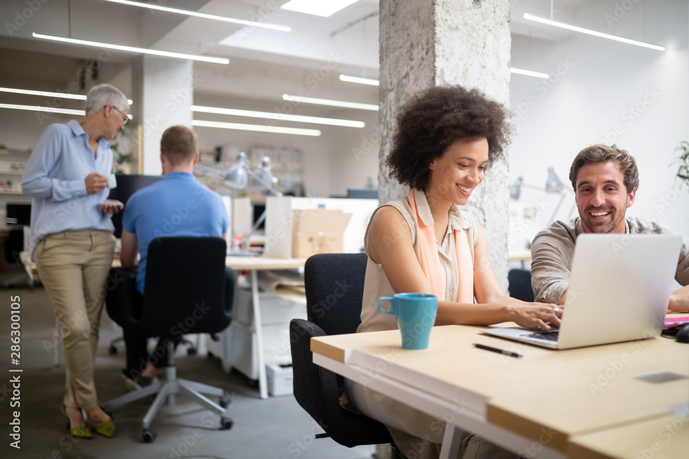 Obraz premium Cheerful coworkers in office during company meeting