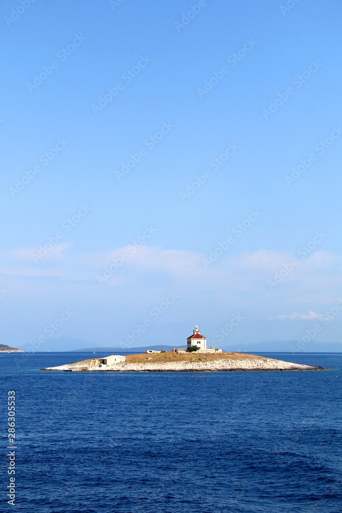 Picturesque lighthouse on a small island near town Hvar, on island Hvar, Croatia.