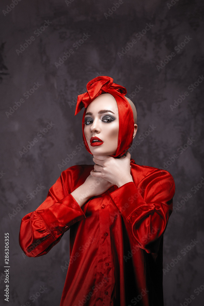 A bald girl with red lips and a red bow on her head strangles herself with  her hands. Fashionable girl in the studio. Sexy babe Stock Photo | Adobe  Stock
