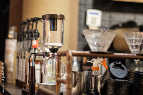 Coffee brewer machine with glass and water at a cafe shop bar © frimufilms