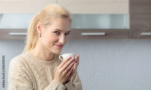 Fototapeta Naklejka Na Ścianę i Meble -  Close-up portrait of a beautiful mid age woman with cup of coffee.