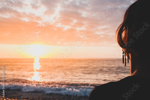 Tableau sur toile Enjoying the sea on a rocky beach, shot from behind the person