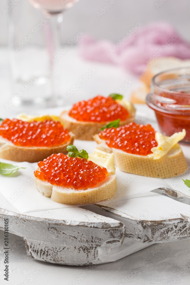Red caviar on baguette toast with butter, appetizer for wine, champagne. Holiday, new year, Christmas, buffet. Delicious canape, food Red caviar on baguette toast with butter, appetizer for wine, champagne. Holiday, new year, Christmas, buffet. Delicious canape, food