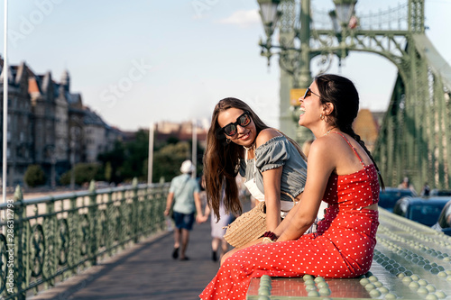 Photography Young women enjoying communication with each other on bridge