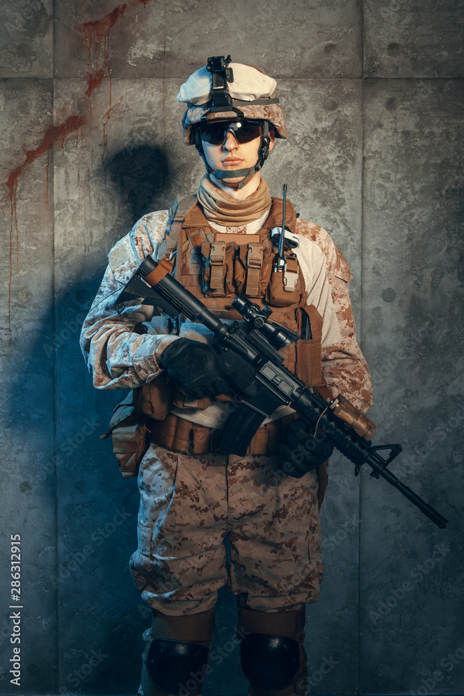 Fototapeta premium Special forces United States soldier or private military contractor holding rifle. Image on a dark background