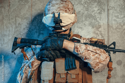 Fototapeta Naklejka Na Ścianę i Meble -  Special forces United States soldier or private military contractor holding rifle. Image on a dark background