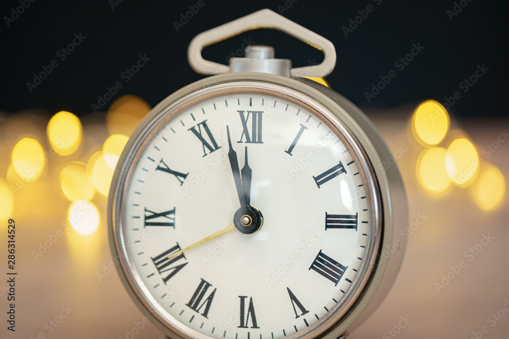 Close up of retro alarm clock on blurred Christmas background with bokeh Close up of retro alarm clock on blurred Christmas background with bokeh